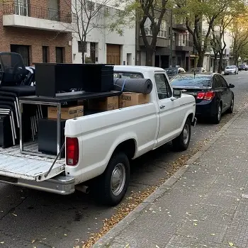 Camioneta cargada con escritorios, sillas y muebles de oficina